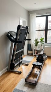 Space-saving cardio machines for home including a foldable treadmill and compact rower