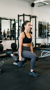 Woman doing a split squat with dumbbells to build leg and glute strength